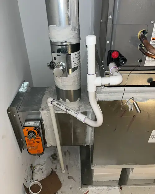 Air handler with condensate piping and a damper actuator