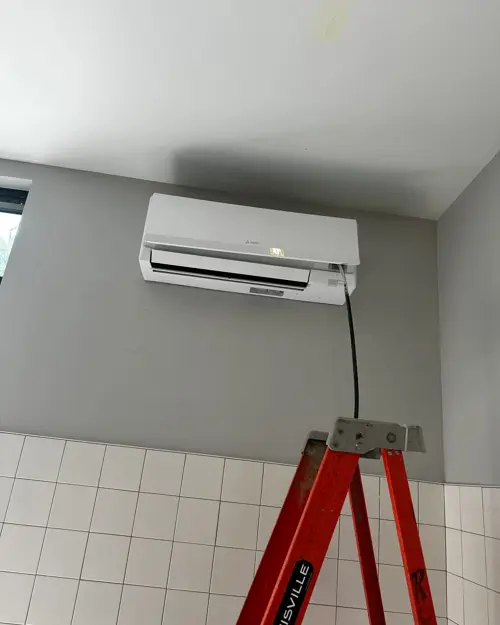 Mini-split head mounted high on a white wall